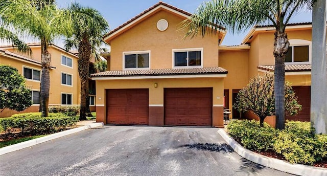1100 Scotia Dr Unit 102, Hypoluxo, FL 33462 - view of front of home featuring an attached garage, stucco siding, asphalt driveway, and a tile roof