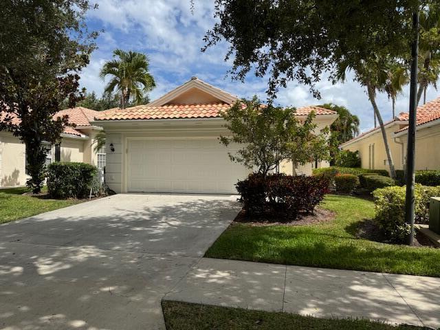 4780 Blossom Dr, Delray Beach, FL 33445 - mediterranean / spanish house with an attached garage, a tile roof, driveway, and stucco siding