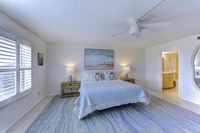 2571 NE Ocean Blvd Unit 104, Stuart, FL 34996 - bedroom featuring light tile patterned floors, a textured ceiling, a ceiling fan, and ensuite bath