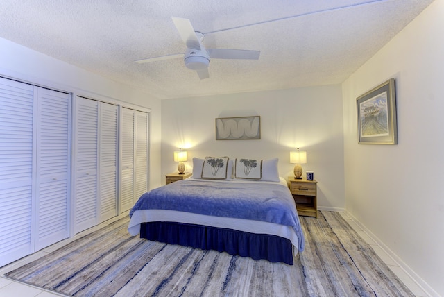 2571 NE Ocean Blvd Unit 104, Stuart, FL 34996 - bedroom with wood finished floors, a textured ceiling, two closets, and a ceiling fan