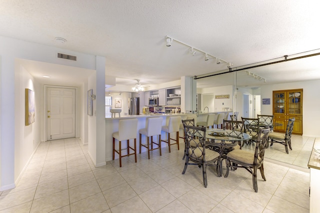2571 NE Ocean Blvd Unit 104, Stuart, FL 34996 - dining room featuring light tile patterned floors, a textured ceiling, and a ceiling fan