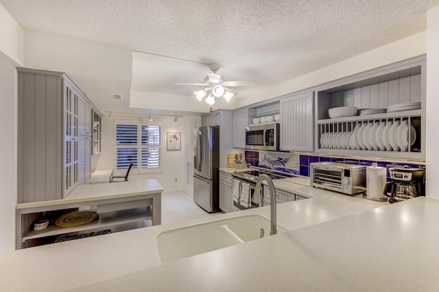 2571 NE Ocean Blvd Unit 104, Stuart, FL 34996 - kitchen with appliances with stainless steel finishes, open shelves, gray cabinets, light countertops, and ceiling fan