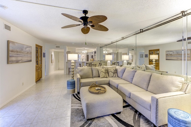 2571 NE Ocean Blvd Unit 104, Stuart, FL 34996 - living room featuring a ceiling fan, light tile patterned floors, and a textured ceiling