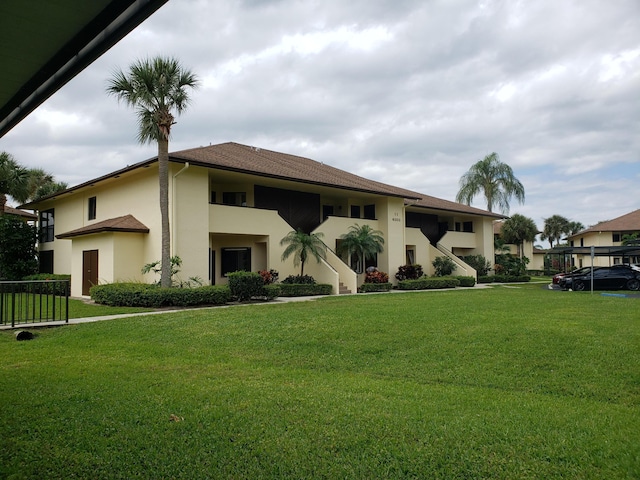6303 SE Williamsburg Dr Unit 201, Hobe Sound, FL 33455 - view of front of house featuring stucco siding and a front yard