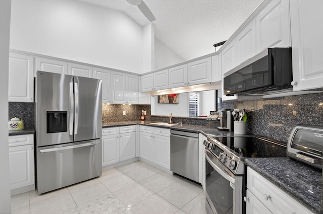 7585 Lexington Club Blvd Unit A, Delray Beach, FL 33446 - kitchen featuring stainless steel appliances, backsplash, light tile patterned flooring, white cabinetry, and a textured ceiling