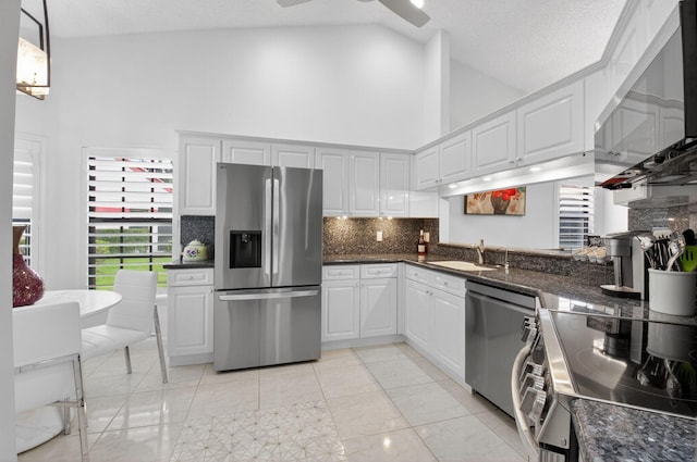 7585 Lexington Club Blvd Unit A, Delray Beach, FL 33446 - kitchen with stainless steel appliances, high vaulted ceiling, ceiling fan, backsplash, and white cabinetry