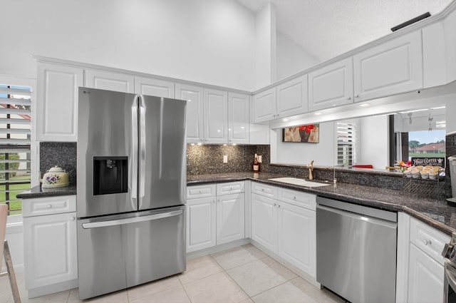 7585 Lexington Club Blvd Unit A, Delray Beach, FL 33446 - kitchen featuring stainless steel appliances, backsplash, white cabinetry, high vaulted ceiling, and light tile patterned flooring