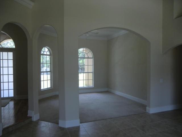 17183 80th St N, The Acreage, FL 33470 - tiled entryway featuring carpet flooring, crown molding, a towering ceiling, and arched walkways