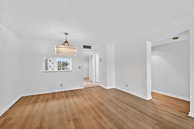 7290 Ashford Pl Unit 201, Delray Beach, FL 33446 - spare room featuring light wood finished floors, a textured ceiling, a chandelier, and a smoke detector