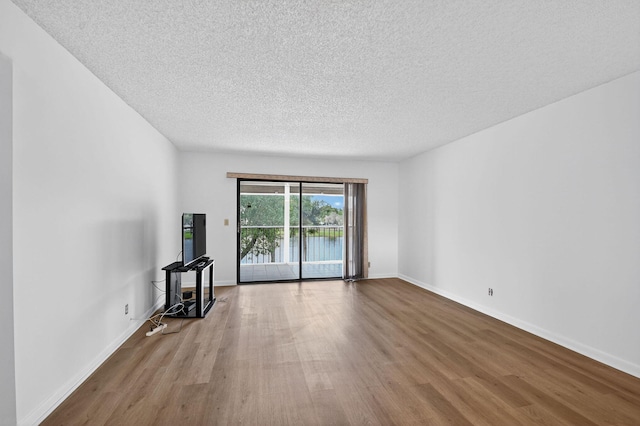 7290 Ashford Pl Unit 201, Delray Beach, FL 33446 - unfurnished living room featuring wood finished floors and a textured ceiling