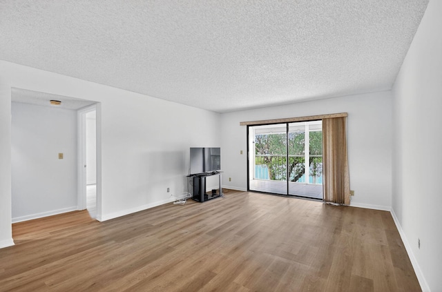 7290 Ashford Pl Unit 201, Delray Beach, FL 33446 - unfurnished living room with light wood-type flooring and a textured ceiling