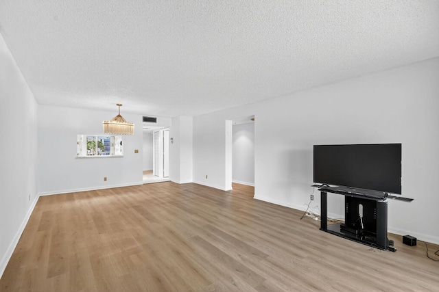 7290 Ashford Pl Unit 201, Delray Beach, FL 33446 - unfurnished living room with a textured ceiling and light wood-style floors