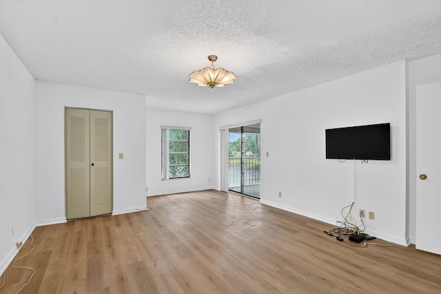 7290 Ashford Pl Unit 201, Delray Beach, FL 33446 - unfurnished living room with light wood-style floors and a textured ceiling