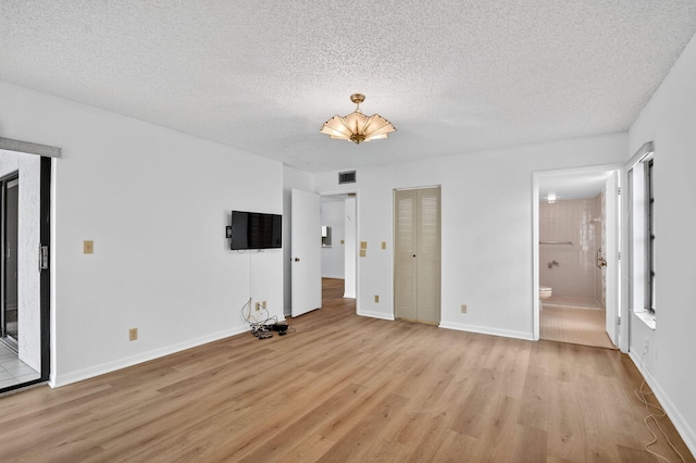 7290 Ashford Pl Unit 201, Delray Beach, FL 33446 - unfurnished bedroom with light wood-style floors, a textured ceiling, and connected bathroom