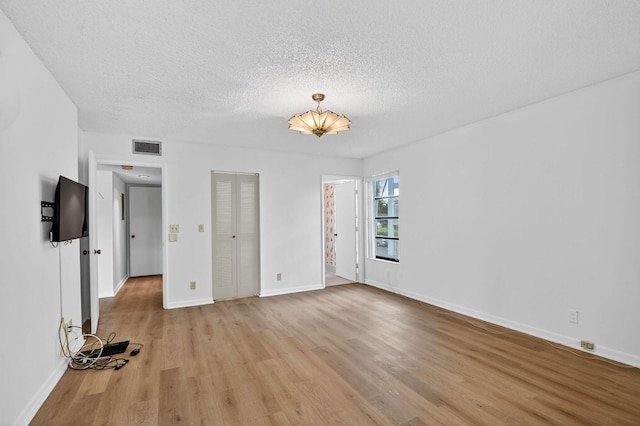 7290 Ashford Pl Unit 201, Delray Beach, FL 33446 - unfurnished bedroom with light wood finished floors, a textured ceiling, and a closet