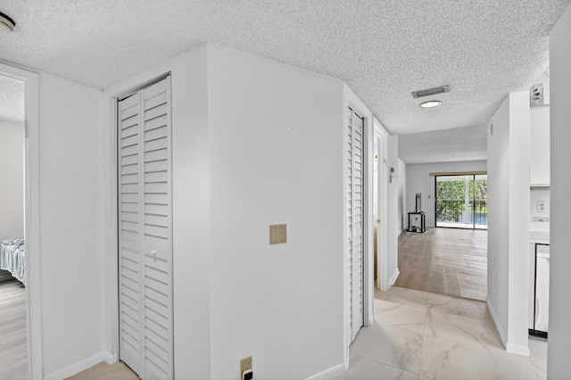 7290 Ashford Pl Unit 201, Delray Beach, FL 33446 - corridor with a textured ceiling and light marble finish floors