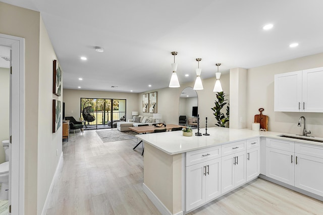 20 Southport Ln Unit D, Boynton Beach, FL 33436 - kitchen featuring light wood-style flooring, white cabinets, light countertops, recessed lighting, and a peninsula