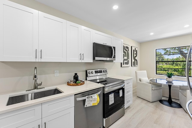 20 Southport Ln Unit D, Boynton Beach, FL 33436 - kitchen featuring stainless steel appliances, recessed lighting, light countertops, white cabinetry, and light wood-style flooring