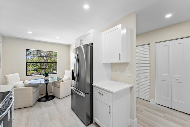 20 Southport Ln Unit D, Boynton Beach, FL 33436 - kitchen featuring stainless steel appliances, open floor plan, light wood-style flooring, light countertops, and white cabinetry
