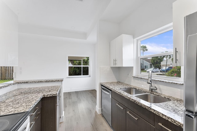 23157 Old Inlet Bridge Dr, Boca Raton, FL 33433 - kitchen featuring appliances with stainless steel finishes, dark brown cabinetry, white cabinets, light wood-style flooring, and decorative backsplash