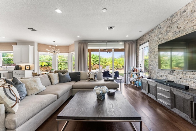 19335 Skyridge Cir, Boca Raton, FL 33498 - living area featuring dark wood-style floors, a chandelier, a textured ceiling, healthy amount of natural light, and recessed lighting