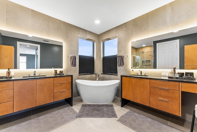 19335 Skyridge Cir, Boca Raton, FL 33498 - bathroom featuring a freestanding tub, two vanities, a stall shower, recessed lighting, and tile walls