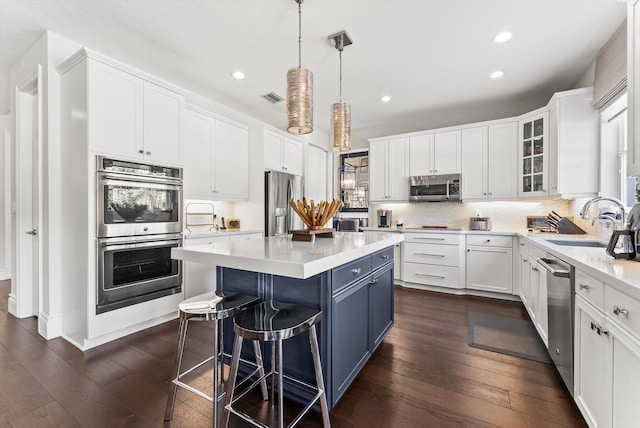 19335 Skyridge Cir, Boca Raton, FL 33498 - kitchen featuring appliances with stainless steel finishes, white cabinetry, recessed lighting, a kitchen island, and dark wood-style floors