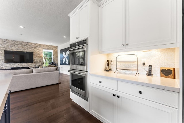 19335 Skyridge Cir, Boca Raton, FL 33498 - kitchen with stainless steel double oven, dark wood-style floors, white cabinetry, recessed lighting, and a textured ceiling
