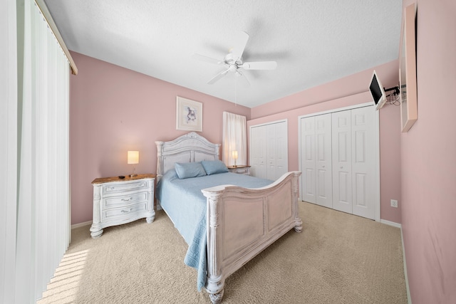 1104 SE Strathmore Dr, Port Saint Lucie, FL 34952 - bedroom featuring light carpet, two closets, a textured ceiling, and ceiling fan