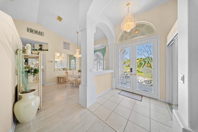 1104 SE Strathmore Dr, Port Saint Lucie, FL 34952 - foyer entrance featuring lofted ceiling, a chandelier, french doors, arched walkways, and wood finished floors