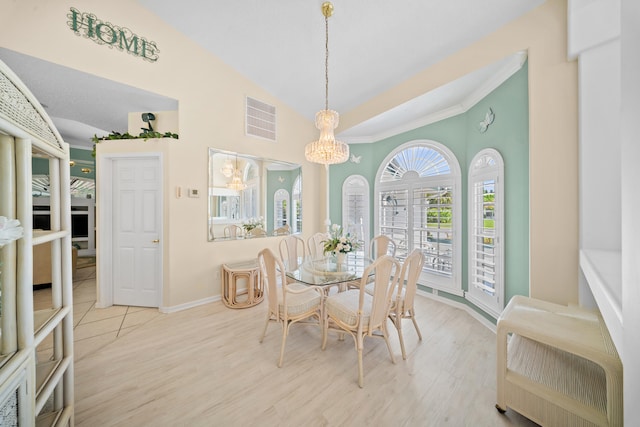 1104 SE Strathmore Dr, Port Saint Lucie, FL 34952 - dining room featuring a chandelier, high vaulted ceiling, wood finished floors, and ornamental molding