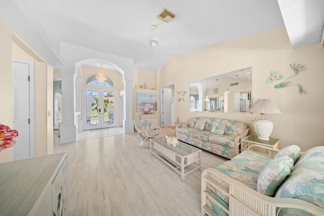 1104 SE Strathmore Dr, Port Saint Lucie, FL 34952 - living room featuring french doors, wood finished floors, arched walkways, and vaulted ceiling