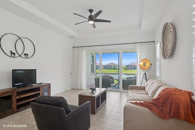9155 SW Michele Way, Port Saint Lucie, FL 34987 - living room with a raised ceiling, light tile patterned floors, ceiling fan, and a water view