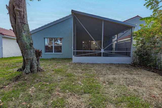8008 Red Reef Ln, Boynton Beach, FL 33436 - back of house with a sunroom, a lawn, and stucco siding