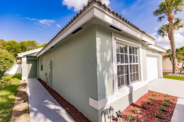 8008 Red Reef Ln, Boynton Beach, FL 33436 - view of home's exterior with stucco siding, concrete driveway, a tile roof, and an attached garage