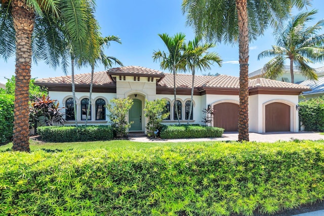 216 Summa St, West Palm Beach, FL 33405 - mediterranean / spanish home featuring a garage, stucco siding, and a tile roof