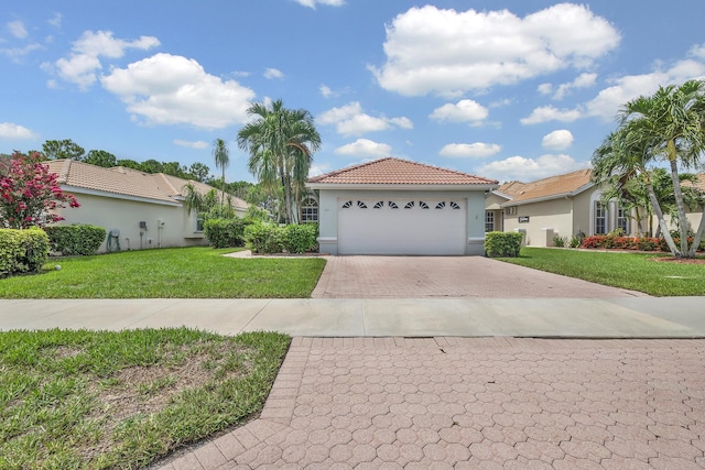 511 SW Treasure Cv, Port Saint Lucie, FL 34986 - mediterranean / spanish house featuring decorative driveway, a front yard, a tiled roof, stucco siding, and a garage