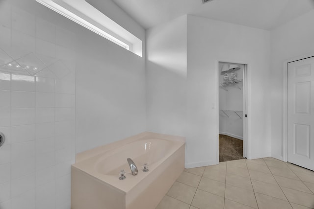 511 SW Treasure Cv, Port Saint Lucie, FL 34986 - bathroom featuring a garden tub, tile patterned floors, and a spacious closet