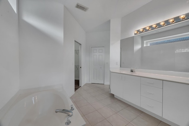 511 SW Treasure Cv, Port Saint Lucie, FL 34986 - full bathroom with a garden tub, vanity, tile patterned flooring, and a spacious closet