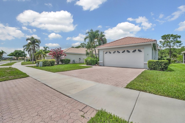 511 SW Treasure Cv, Port Saint Lucie, FL 34986 - mediterranean / spanish-style house with a front yard, a tiled roof, driveway, and stucco siding