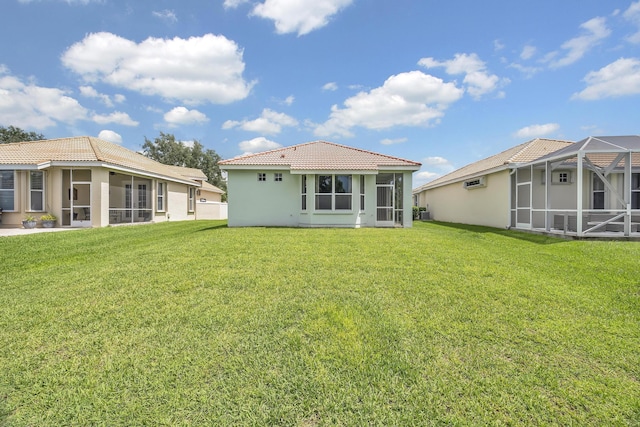 511 SW Treasure Cv, Port Saint Lucie, FL 34986 - rear view of house featuring a tile roof, stucco siding, a yard, and a sunroom