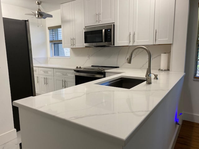2975 SW 22nd Ave Unit 2010, Delray Beach, FL 33445 - kitchen featuring stainless steel appliances, light stone counters, white cabinets, and ceiling fan