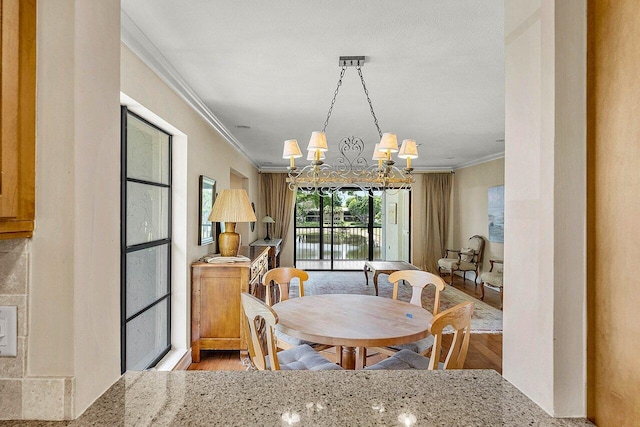 45 Stratford Ln Unit B, Boynton Beach, FL 33436 - dining space featuring ornamental molding, wood finished floors, and a chandelier