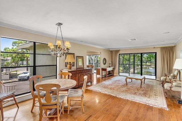 45 Stratford Ln Unit B, Boynton Beach, FL 33436 - dining room featuring crown molding, light wood-style floors, and a chandelier