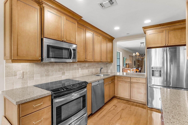45 Stratford Ln Unit B, Boynton Beach, FL 33436 - kitchen with stainless steel appliances, light wood-style flooring, ornamental molding, tasteful backsplash, and light stone countertops