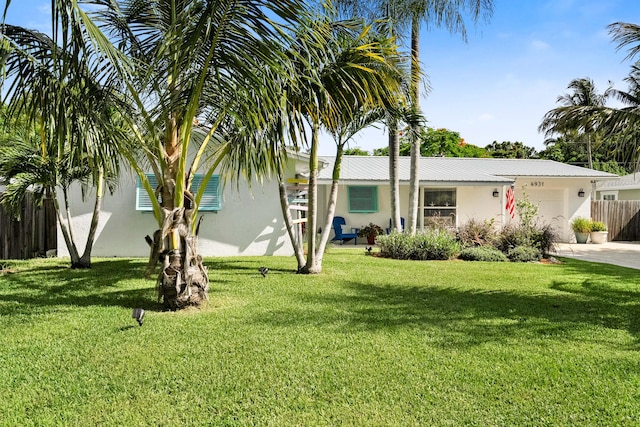 4931 SE Pompano Ter, Stuart, FL 34997 - view of front facade with stucco siding, a garage, a metal roof, and concrete driveway