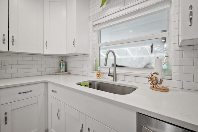 4931 SE Pompano Ter, Stuart, FL 34997 - kitchen with tasteful backsplash, white cabinetry, light countertops, and dishwasher