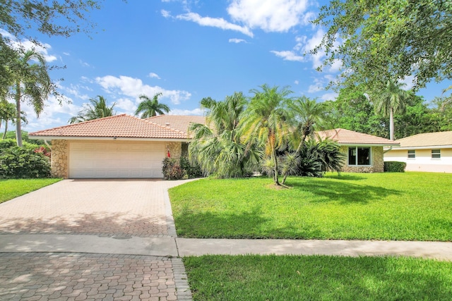 7197 Encina Ln, Boca Raton, FL 33433 - view of front of property with a tile roof, stone siding, decorative driveway, a front yard, and a garage