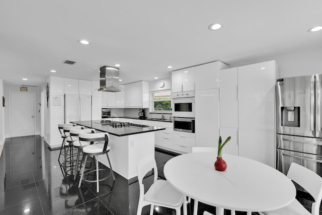 7197 Encina Ln, Boca Raton, FL 33433 - kitchen with appliances with stainless steel finishes, island range hood, modern cabinets, a kitchen bar, and recessed lighting