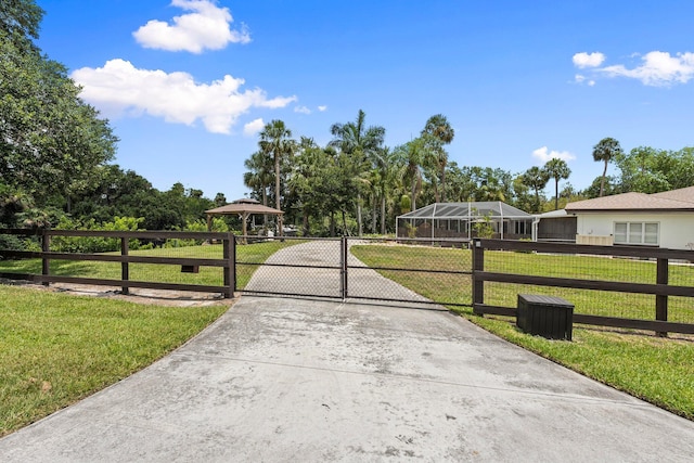 1400 Parkland Blvd, Fort Pierce, FL 34982 - view of front of home with driveway, a gate, and view of wooded area
